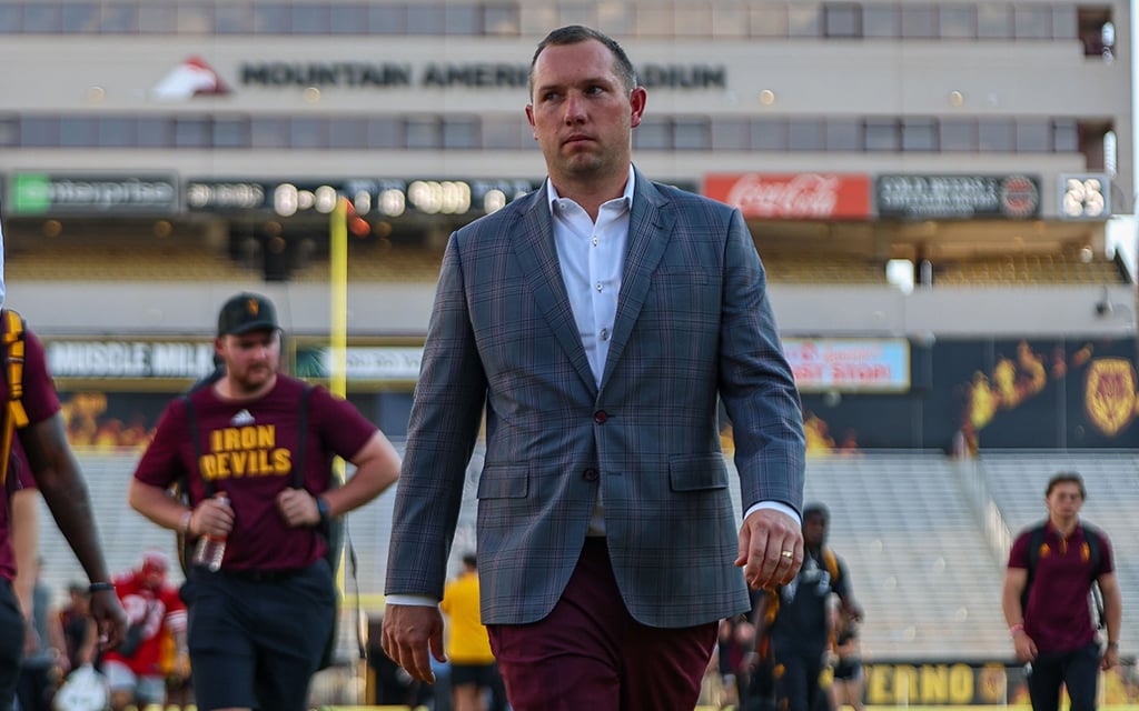 Kenny Dillingham in a suit walking into Mountain America Stadium