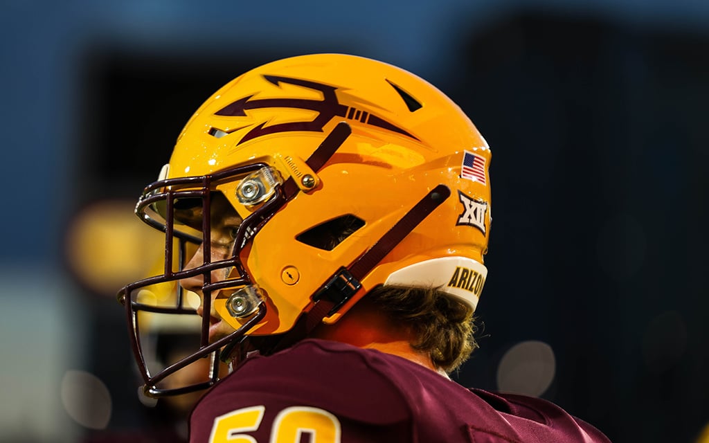 Arizona State football player wearing a gold helmet with maroon pitchfork decal and a maroon jersey.