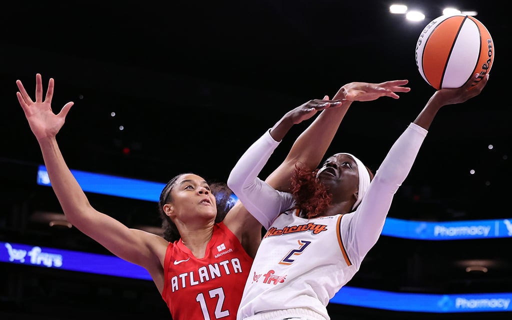 Phoenix Mercury leading scorer Kahleah Copper in orange jersey shooting or passing the basketball.