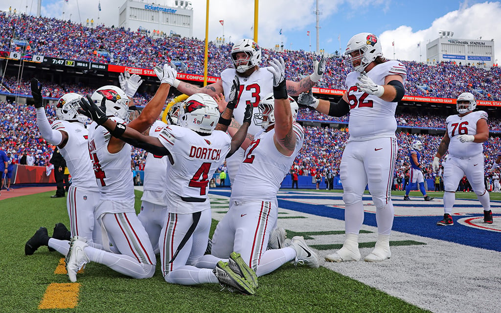 Arizona Cardinals football players celebrating in the end zone during a game.