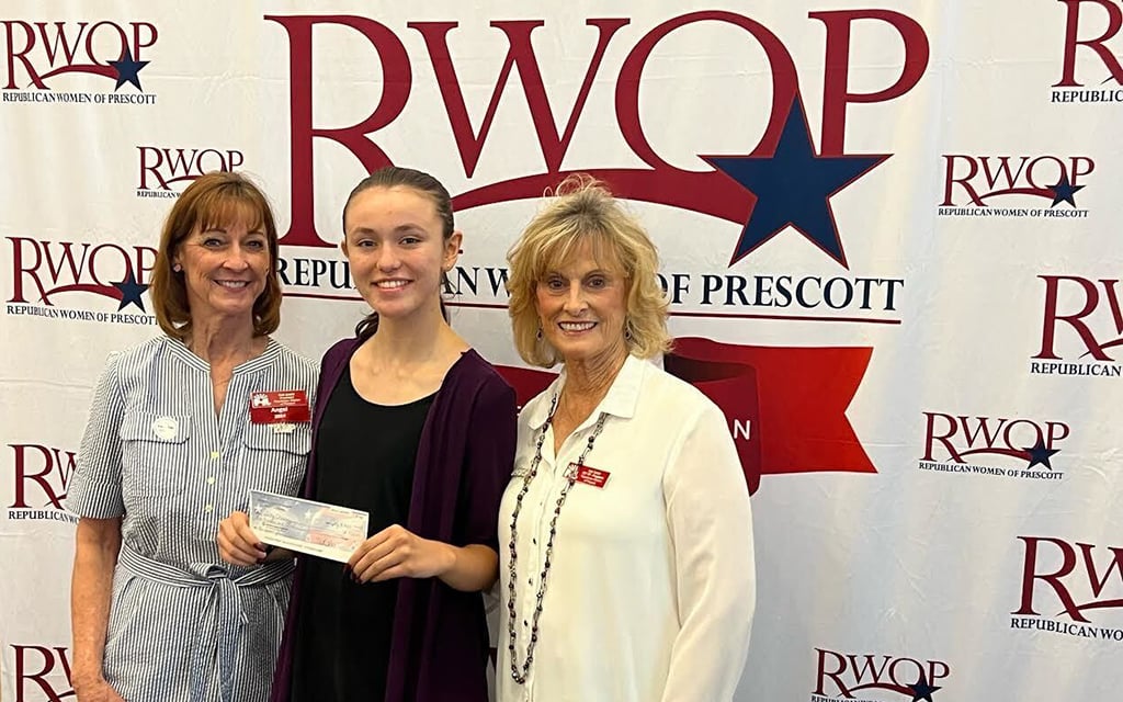 Gabby Ehmann, center, with Sue Davis, left, and Sue Tatar smiling and standing in front of a backdrop with "RWOP Republican Women of Prescott" logos.