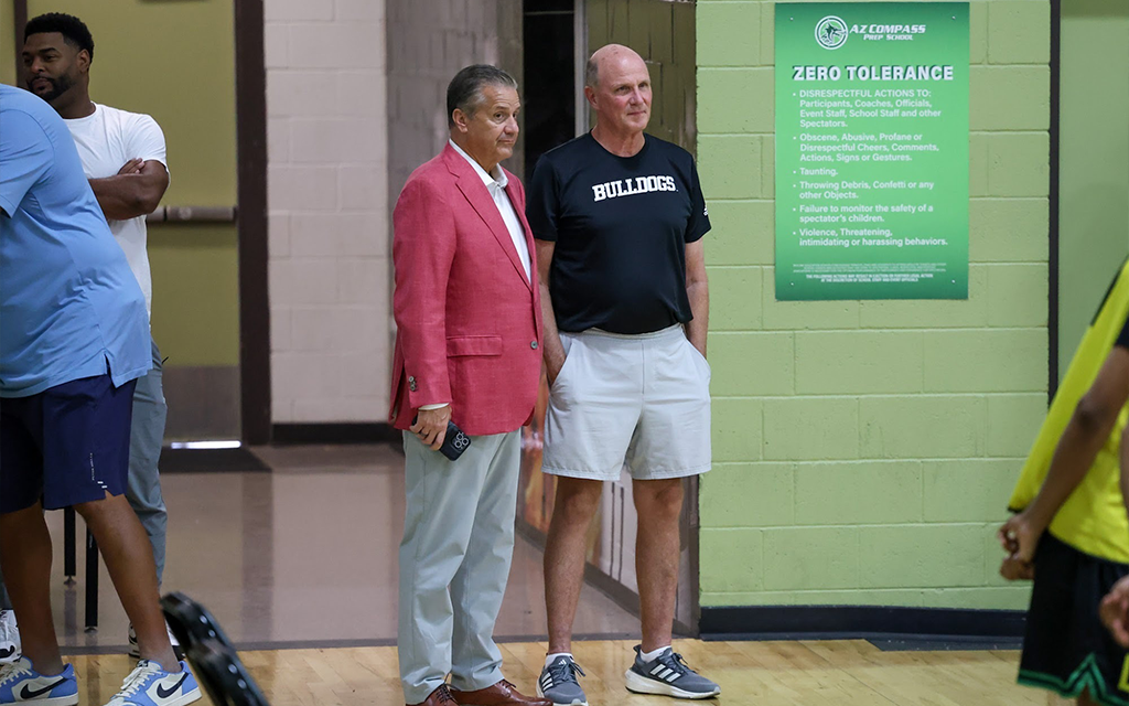 John Calipari stands to the right of a coach while watching recruits at the AZ Compass Prep pro day.