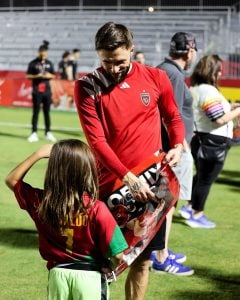 Phoenix Rising forward Dariusz Formella smiles while talking to young fan