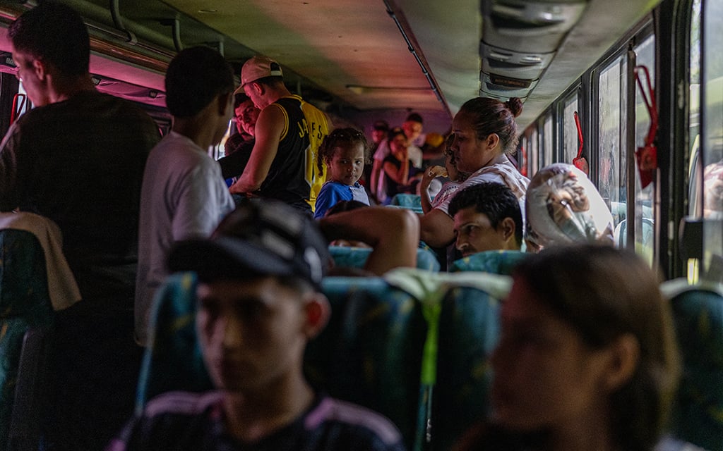 Migrant families take their seats on a bus chartered by Costa Rican government for the next leg of a trip north toward the United States. (Photo by Christopher Lomahquahu/Cronkite Borderlands Project)