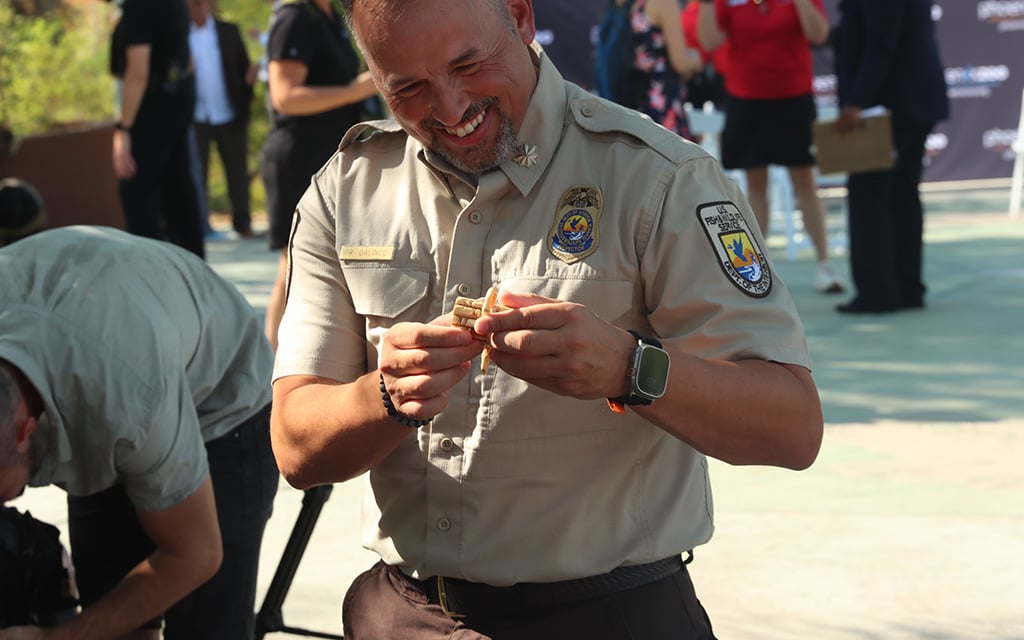 Rene Galindo, an inspector with the U.S. Fish & Wildlife Service, inspects a piece of ivory surrendered at the “Toss the Tusk” event at the Phoenix Zoo on Sept. 27, 2024. (Photo by Aryton Temcio/Cronkite News)