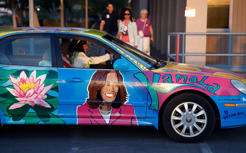 Gretchen Baer, an Arizona artist, shows her support for Vice President Kamala Harris in a car decorated with Harris-themed paintings in Douglas on Sept. 27, 2024. (Photo by Gabriel Garza/Cronkite News)