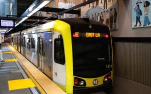 A commuter train heading to East LA at a station platform.