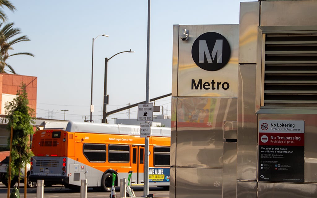 LA Metro building with signage and orange bus on the street.