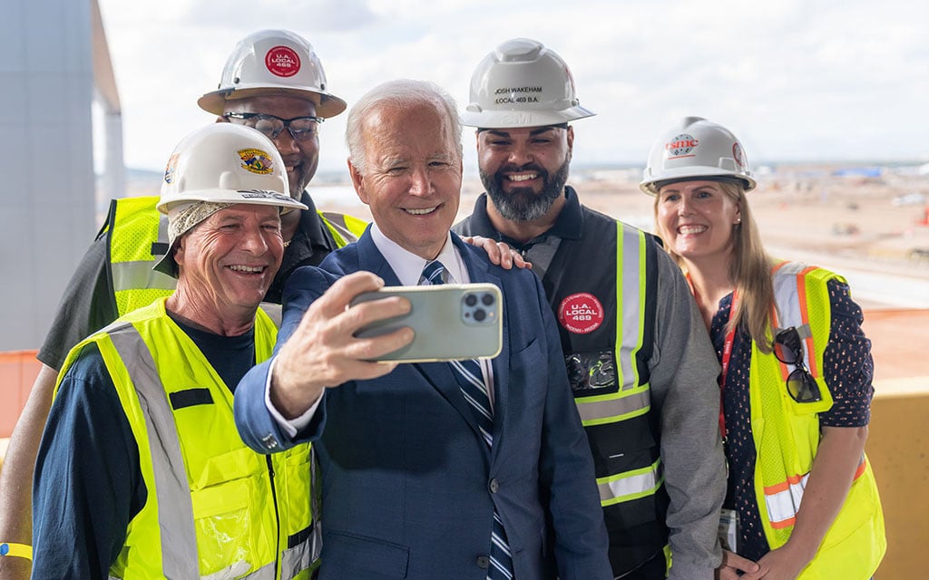 President Joe Biden poses for a selfie with workers during a tour of the TSMC Semiconductor Plant in Phoenix on Dec. 6, 2022.