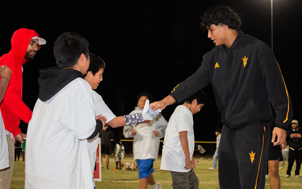 Arizona State wide receiver Xavier Guillory shares high-fives with children.