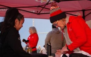 A Fiesta Bowl volunteer assists a young participant with registration.