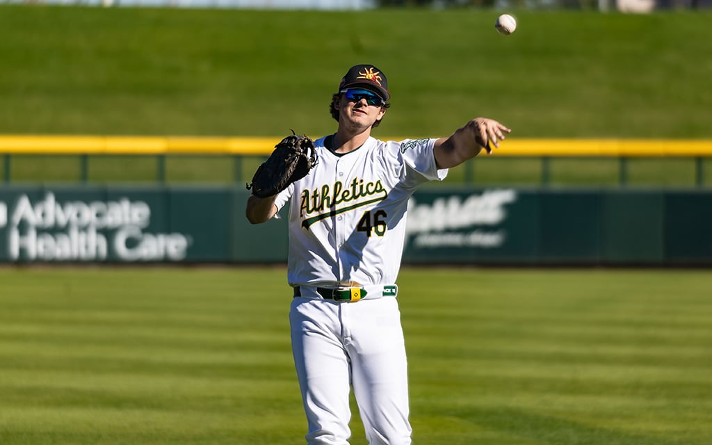 Oakland Athletics prospect Nick Kurtz throws a baseball to warm up for a game.