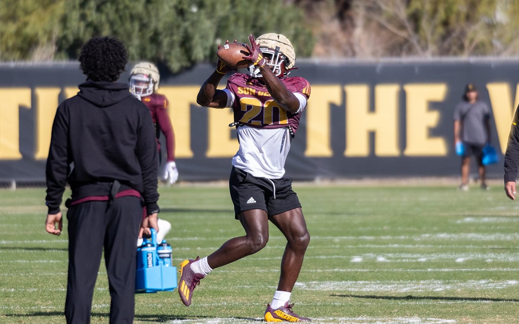 Alton McCaskill catches a ball during practice on a grassy field.