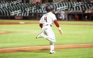 Baseball player runs home from third base